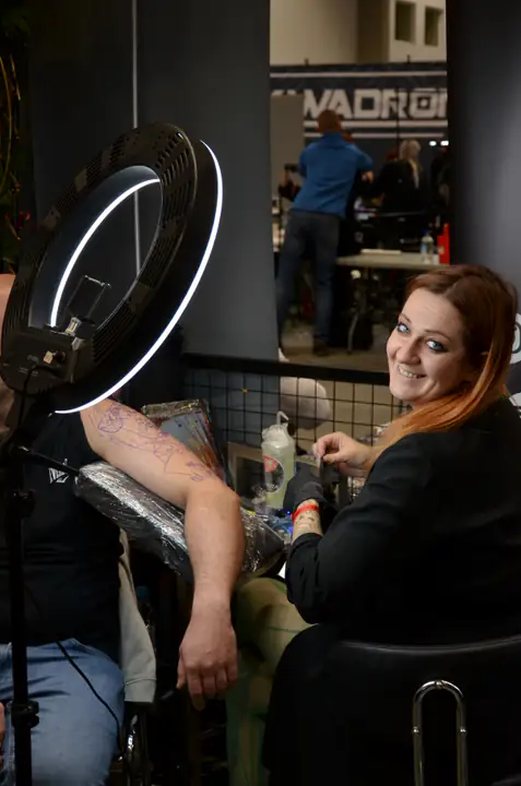 Tatuatorka Yakuza przy stanowisku oświetlonym lampą pierścieniową