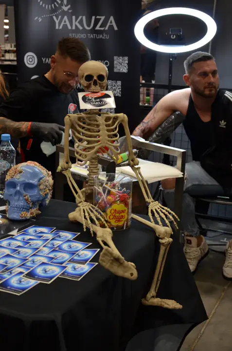 Szkielet i dekoracje przed stanowiskiem pracujących tatuatorów